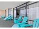 Spacious balcony with multiple teal chairs and sliders leading inside at 501 S Ocean Blvd. # 505, North Myrtle Beach, SC 29582