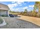 Expansive backyard featuring a patio, grill, dining set, and well-maintained lawn perfect for outdoor entertaining at 980 Desert Wheatgrass Dr., Myrtle Beach, SC 29579