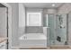 Bathroom featuring a soaking tub with marble tile surround and separate glass shower on wood floors at 980 Desert Wheatgrass Dr., Myrtle Beach, SC 29579