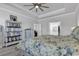 Bright main bedroom featuring a ceiling fan, decor shelves, and a bed with floral bedding on wood floors at 980 Desert Wheatgrass Dr., Myrtle Beach, SC 29579