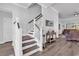 Bright foyer with staircase featuring wood treads and white risers, complemented by wood-look flooring and wainscoting details at 980 Desert Wheatgrass Dr., Myrtle Beach, SC 29579