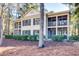 A view of the screened-in porch, surrounded by lush landscaping, in a beautiful home at 14 Stillwood Dr. # 2, Pawleys Island, SC 29585