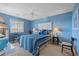 Bedroom with blue walls features a ceiling fan and a window for natural light at 1900 Duffy St. # C-7, North Myrtle Beach, SC 29582