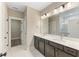 Bathroom with double sink vanity, dark cabinetry, large mirror, and marble floors at 217 Wahee Pl., Conway, SC 29527