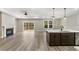 Open floor plan with fireplace, deck access, island seating, and modern pendant lighting at 217 Wahee Pl., Conway, SC 29527