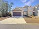 Two-story house with beige siding, two-car garage, and manicured lawn at 220 Machrie Loop # A, Myrtle Beach, SC 29588
