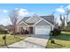 Gray house with stone accents, white garage door, and landscaping at 417 San Benito Ct., Longs, SC 29568