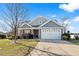 Gray house with stone accents, white garage door, and landscaping at 417 San Benito Ct., Longs, SC 29568
