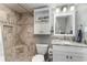 Updated bathroom with granite vanity, tile shower, and built-in shelving at 501 S Ocean Blvd. # 304, North Myrtle Beach, SC 29582