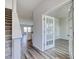 Bright entryway featuring stylish gray floors, staircase, and glass french doors to the office at 808 St. Albans Loop, Conway, SC 29526