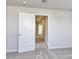 A hallway with neutral walls and carpet and an open door at 808 St. Albans Loop, Conway, SC 29526