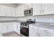 Close up on stainless steel gas range and microwave with granite countertops and white cabinets at 808 St. Albans Loop, Conway, SC 29526