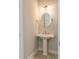 Small powder room with pedestal sink and round mirror at 8091 Laurel Ash Ave., Myrtle Beach, SC 29572
