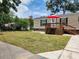 Tan mobile home with deck, red umbrella, and grassy yard at 818 Wayne St., North Myrtle Beach, SC 29582