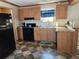 Modern kitchen with wood cabinets, black appliances, and tile flooring at 818 Wayne St., North Myrtle Beach, SC 29582