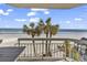 Picturesque balcony view overlooking the beach and a line of palm trees at 1012 N Waccamaw Dr. # 204, Murrells Inlet, SC 29576