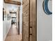 Hallway featuring hardwood floors, exposed beams, and stylish sliding barn doors at 1012 N Waccamaw Dr. # 204, Murrells Inlet, SC 29576