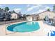 Community pool with surrounding lounge chairs and patio tables at 107 Maddux Ln. # E, Myrtle Beach, SC 29588