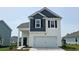 Charming two-story home featuring a clean white garage door and complementary blue accents at 1119 Black Lake Way, Conway, SC 29526