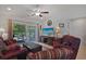 Bright living room with a large TV, red leather couches, and sliding glass doors leading to the patio at 132-A Machrie Loop # A, Myrtle Beach, SC 29588