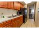 Condo kitchen with wood cabinets, appliances, and dining area view at 1501 S Ocean Blvd. # 1542, Myrtle Beach, SC 29577