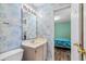 En suite bathroom with vanity, blue wallpaper, and an open door into a bedroom at 2022 N Waccamaw Dr., Garden City Beach, SC 29576