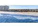 Coastal aerial showcases colorful beach homes nestled next to ocean waves and white sand at 2022 N Waccamaw Dr., Garden City Beach, SC 29576