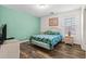 Bedroom with wood floors, sea-green walls, a queen bed and a small dresser next to a window at 2022 N Waccamaw Dr., Garden City Beach, SC 29576