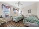 Bedroom with two twin beds, wood floors, ceiling fan, and natural light from two windows at 2022 N Waccamaw Dr., Garden City Beach, SC 29576