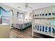 Bedroom with bunk beds, ceiling fan, wood floors, and a window with light coming through at 2022 N Waccamaw Dr., Garden City Beach, SC 29576