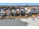 Colorful beach houses on stilts sit on a sandy beach with wooden walkways leading to the shore at 2022 N Waccamaw Dr., Garden City Beach, SC 29576