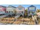 Exterior view of pastel-colored beach houses on stilts with boardwalk access at 2022 N Waccamaw Dr., Garden City Beach, SC 29576