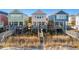 Beachfront homes featuring raised decks, ocean views, and private beach access via wooden walkways at 2022 N Waccamaw Dr., Garden City Beach, SC 29576