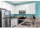 Bright kitchen with stainless steel appliances, white cabinets, tile countertops, and view to the other rooms at 2022 N Waccamaw Dr., Garden City Beach, SC 29576