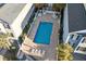 Aerial view of a private rectangular pool with brick surround, white fence, and lounge chairs at 2022 N Waccamaw Dr., Garden City Beach, SC 29576
