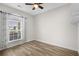 Bright bedroom with wood-look floors, ceiling fan, and window with curtains at 209 Wando River Rd. # 10C, Myrtle Beach, SC 29579