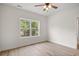 A bright bedroom features wood-look flooring and a large window for natural light and tree views at 2428 Park St., North Myrtle Beach, SC 29582