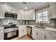 Modern kitchen featuring stainless steel appliances, white cabinets, and gray backsplash at 301 43Rd Ave. N, North Myrtle Beach, SC 29582