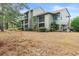 View of the back of the building from the lawn with screened in porches on each floor at 401 Indian Wells Ct. # 401, Murrells Inlet, SC 29576
