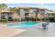 Community pool with exterior view of condo building and furniture around the pool at 401 Indian Wells Ct. # 401, Murrells Inlet, SC 29576