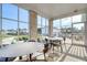 Enclosed sunroom with large windows offering panoramic views, seating, and access to outdoor community features at 4040 Bucolic Loop, Myrtle Beach, SC 29588