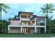 Rear elevation of a luxurious home with multiple stories and covered balconies, set against lush landscaping and palm trees at 4702 N Ocean Blvd., Myrtle Beach, SC 29577