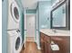 A bathroom features a modern vanity, stacked washer/dryer, and a tiled floor at 661 Tupelo Ln. # 16B, Longs, SC 29568