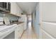 Efficient galley kitchen features white cabinets, stove, microwave, and ocean view at 6900 N Ocean Blvd. # 1439, Myrtle Beach, SC 29572