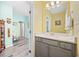 Bright bathroom featuring gray vanity with solid surface counter top, framed mirror, and wood-look floors at 731 Yokley Ct., Surfside Beach, SC 29575