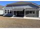 Home with backyard featuring screened-in porch and awnings, offering a blend of indoor-outdoor living at 1519 Wood Stork Dr., Conway, SC 29526