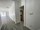 Hallway features modern gray wood flooring, white trim, and leads to the living area with natural light at 1519 Wood Stork Dr., Conway, SC 29526