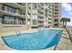 Relaxing pool area with building in background at 1990 N Waccamaw Dr. # 1109, Garden City Beach, SC 29576