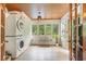 Laundry room with stackable washer and dryer, built-in shelving, and sunroom access at 245 Windover Dr., Pawleys Island, SC 29585