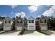 New townhomes featuring varied siding, black shutters, one-car garages, and private driveways under a partly cloudy sky at 265 Christiana Ln. # C, Myrtle Beach, SC 29579